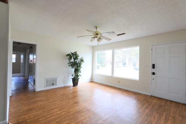 foyer with dark hardwood / wood-style floors, ceiling fan, and a textured ceiling