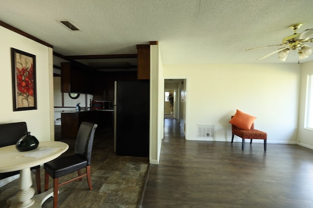 dining space featuring a textured ceiling, dark wood finished floors, a ceiling fan, and visible vents