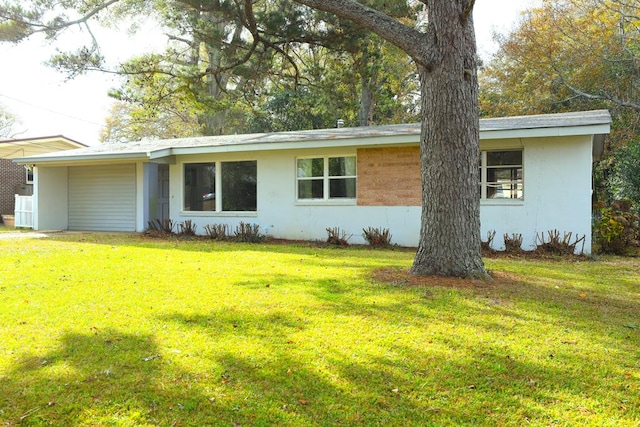 ranch-style home featuring an attached carport, stucco siding, and a front lawn