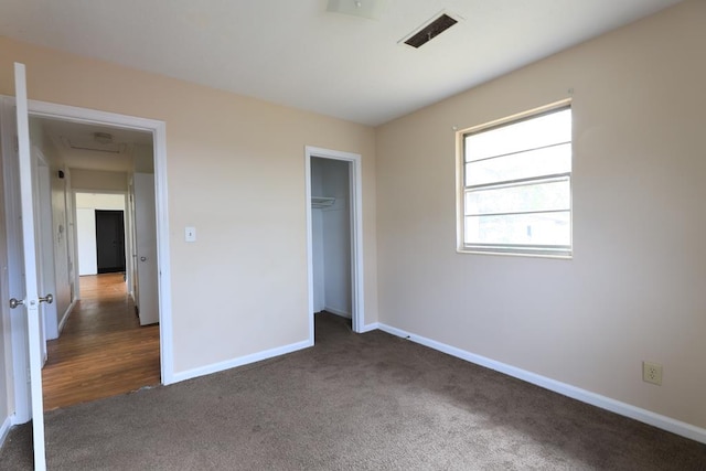 unfurnished bedroom featuring a closet and dark colored carpet