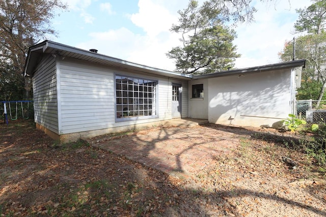 rear view of property with a trampoline