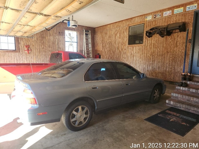 garage featuring a garage door opener and wood walls