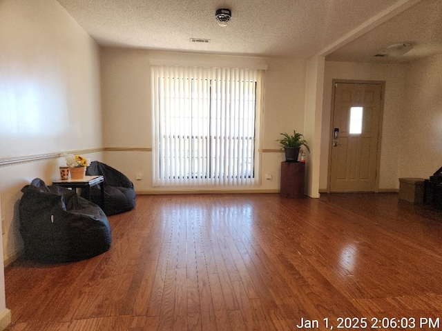 sitting room with hardwood / wood-style floors and a textured ceiling