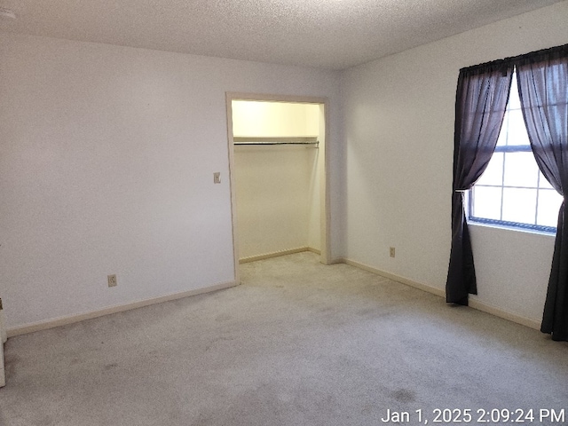 unfurnished bedroom featuring light colored carpet and a closet