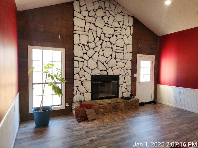 unfurnished living room with a fireplace, dark hardwood / wood-style flooring, and high vaulted ceiling