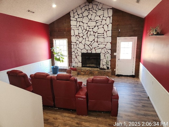 living room featuring a fireplace, dark hardwood / wood-style floors, vaulted ceiling, and plenty of natural light