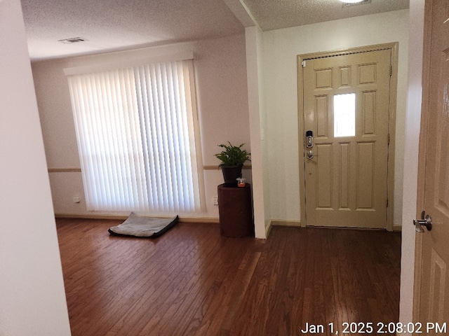 entryway featuring dark hardwood / wood-style flooring and a textured ceiling