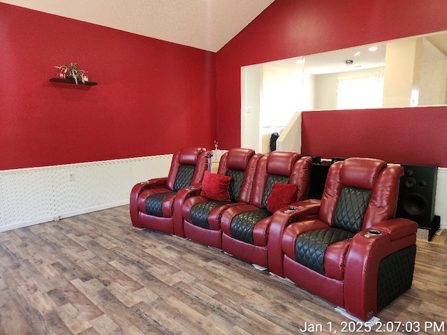 home theater room with hardwood / wood-style flooring and lofted ceiling