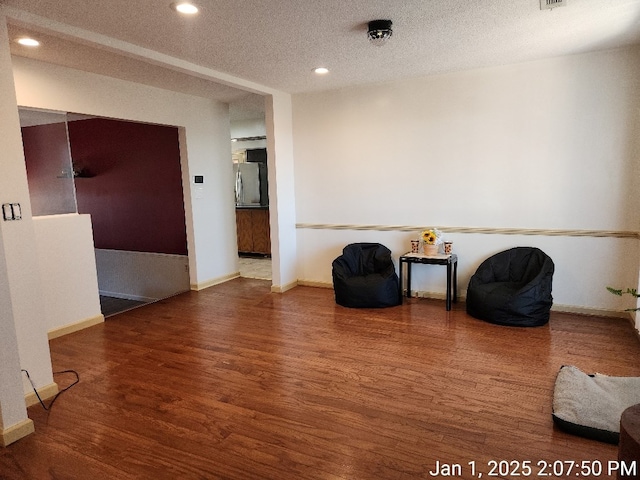 unfurnished room with a textured ceiling and hardwood / wood-style flooring