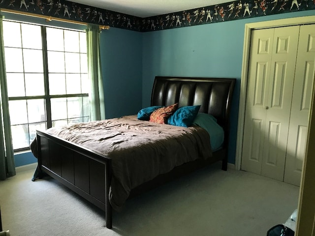 bedroom featuring light colored carpet and a closet