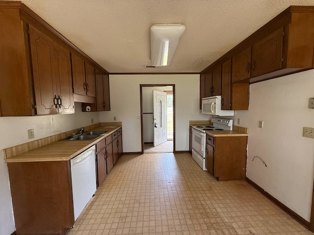 202 Candace Ct, Dothan, AL 36301 - kitchen with white appliances, a sink, light flooring, baseboards, and light countertops