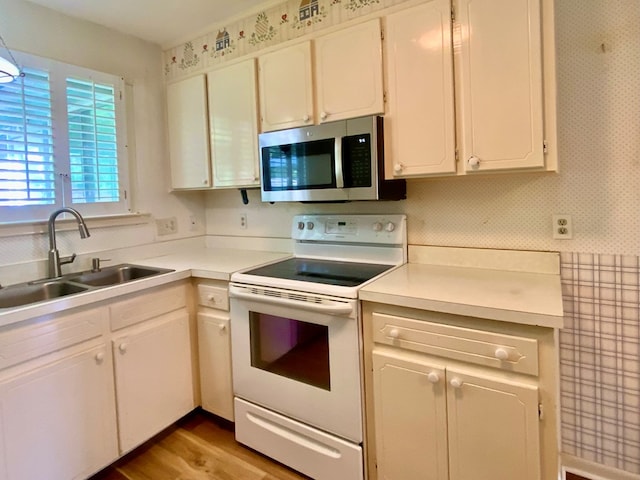 103 Peartree Cir, Dothan, AL 36301 - kitchen with stainless steel microwave, white electric stove, a sink, wallpapered walls, and white cabinets