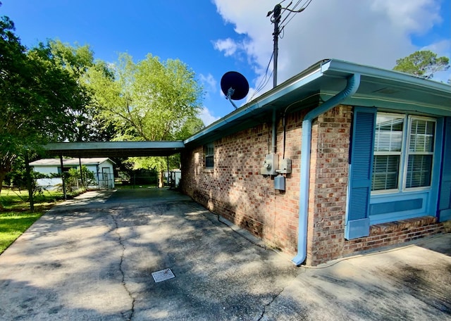 103 Peartree Cir, Dothan, AL 36301 - view of home's exterior with a storage shed, brick siding, driveway, an outbuilding, and an attached carport