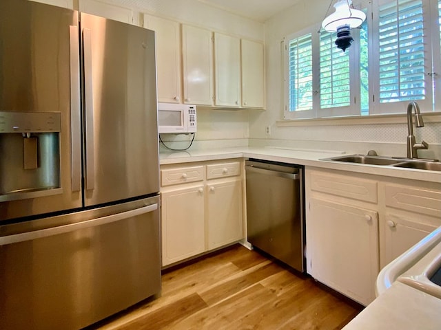 103 Peartree Cir, Dothan, AL 36301 - kitchen with appliances with stainless steel finishes, a sink, light wood-type flooring, light countertops, and white cabinets