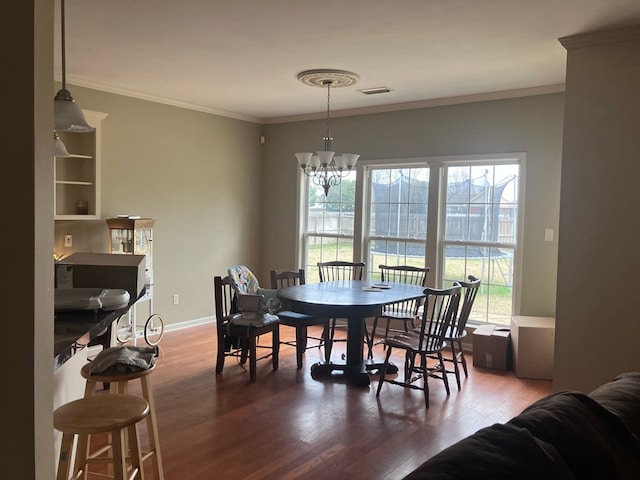 dining room with ornamental molding, wood finished floors, visible vents, and a healthy amount of sunlight