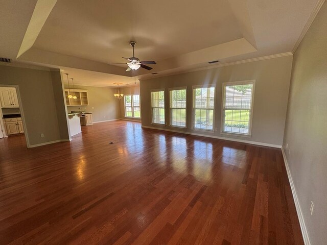 108 Sunshine Ln, Dothan, AL 36303 - unfurnished living room with a tray ceiling, a chandelier, baseboards, a ceiling fan, and dark wood-type flooring