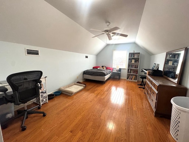 bedroom featuring lofted ceiling, visible vents, light wood-style floors, a ceiling fan, and baseboards