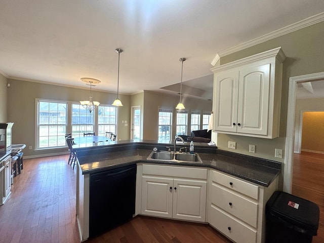 kitchen featuring a peninsula, a sink, black dishwasher, dark wood-style floors, and dark countertops