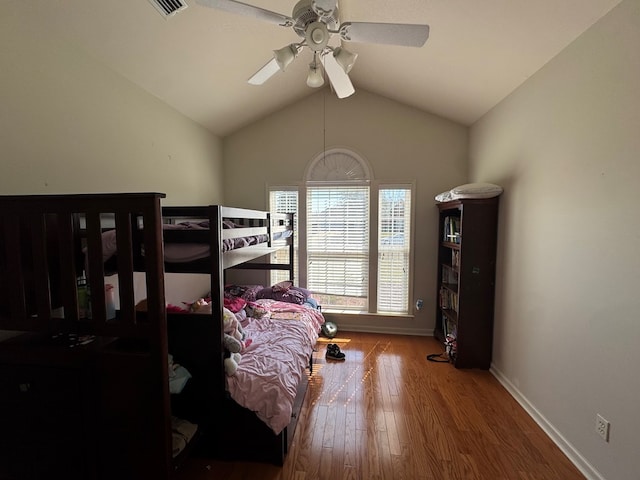 bedroom featuring visible vents, baseboards, a ceiling fan, lofted ceiling, and wood finished floors