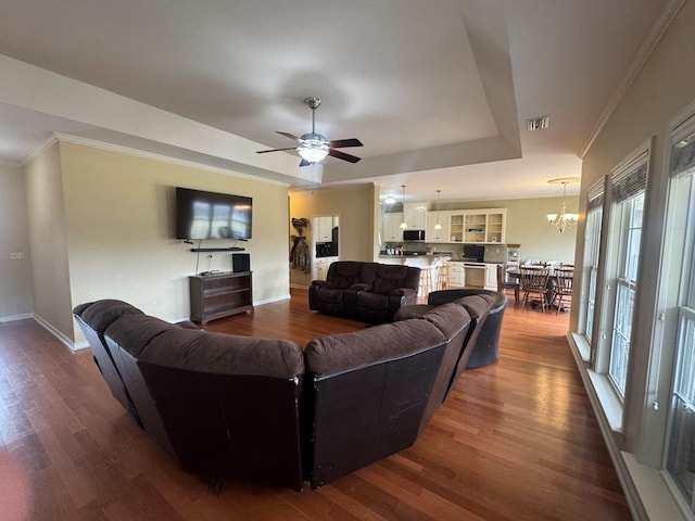 living room featuring baseboards, visible vents, a raised ceiling, and dark wood finished floors