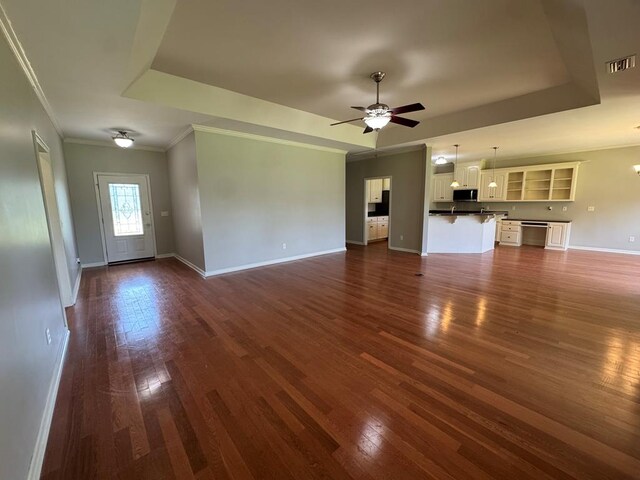 108 Sunshine Ln, Dothan, AL 36303 - unfurnished living room featuring dark wood-style floors, a tray ceiling, baseboards, and crown molding