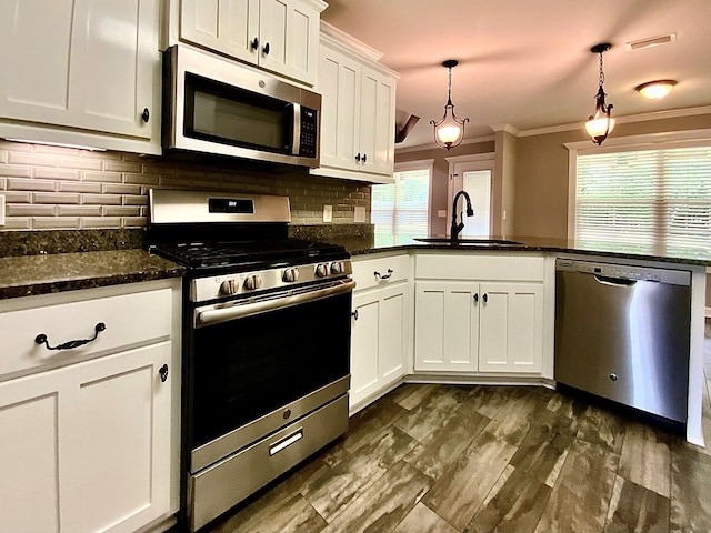503 Cedar Grove Ln, Enterprise, AL 36330 - kitchen with stainless steel appliances, crown molding, tasteful backsplash, white cabinetry, and a peninsula