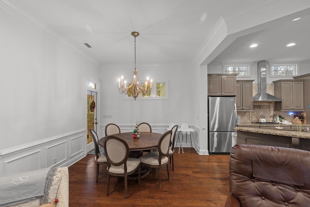 dining room featuring dark hardwood / wood-style flooring, crown molding, and a chandelier