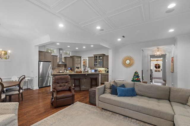 living room featuring crown molding, a healthy amount of sunlight, dark hardwood / wood-style floors, and a notable chandelier