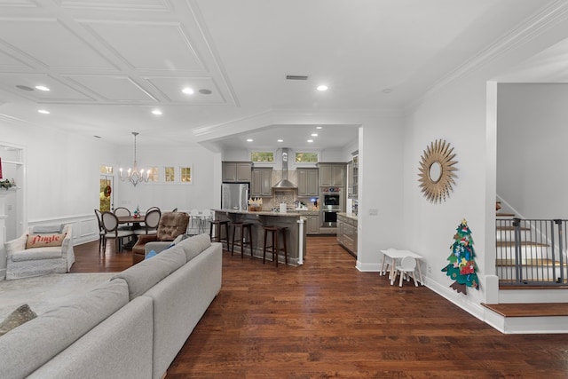 living room featuring crown molding, dark wood-type flooring, and a notable chandelier