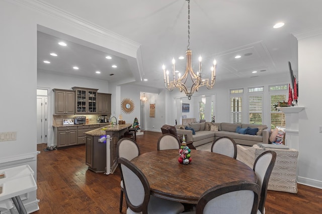 dining space featuring sink, a notable chandelier, dark hardwood / wood-style flooring, and crown molding