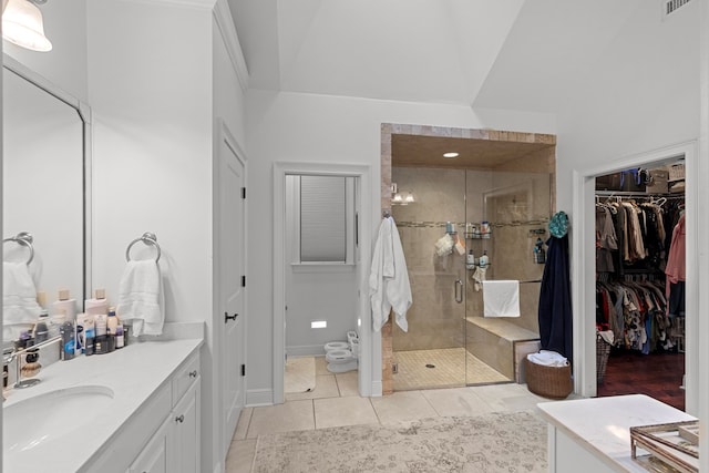 bathroom featuring tile patterned flooring, vanity, a shower with door, and vaulted ceiling