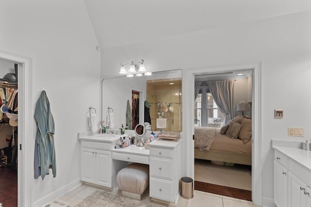 bathroom with tile patterned flooring, vanity, vaulted ceiling, and a shower with shower door