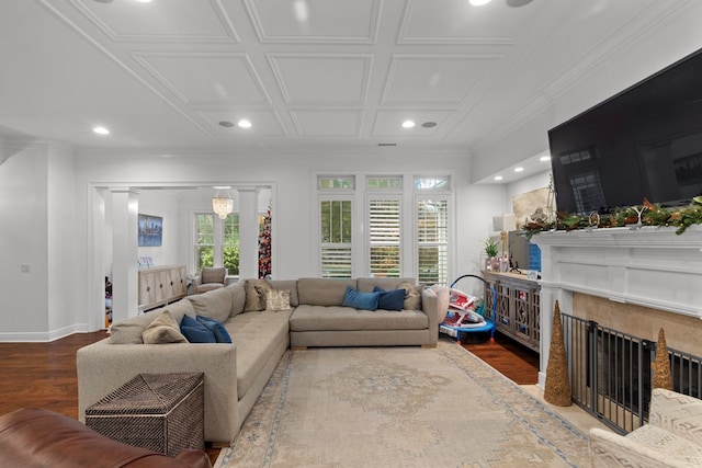 living room featuring hardwood / wood-style flooring, ornamental molding, a high end fireplace, and coffered ceiling