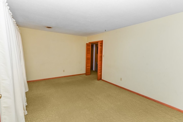 unfurnished room featuring light colored carpet and a textured ceiling