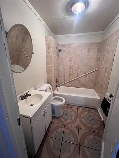 full bathroom with tiled shower / bath, tile patterned floors, toilet, vanity, and ornamental molding