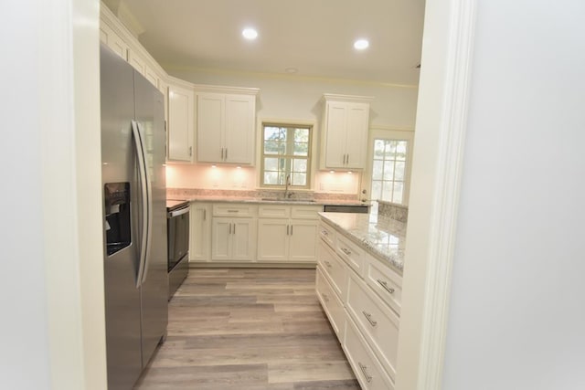 kitchen featuring white cabinets, sink, stainless steel appliances, and light hardwood / wood-style flooring