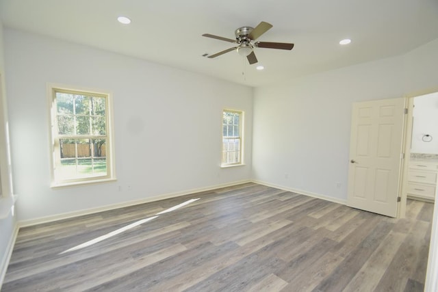 empty room featuring plenty of natural light, ceiling fan, and light hardwood / wood-style flooring