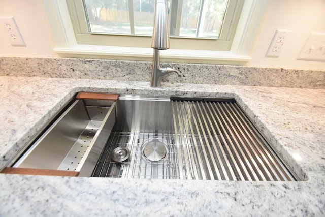 room details with light stone countertops and sink