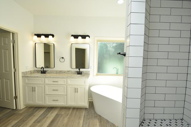 bathroom featuring hardwood / wood-style flooring, vanity, and separate shower and tub