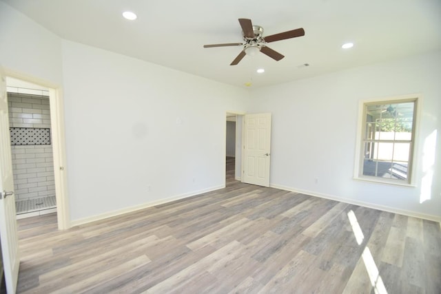 unfurnished bedroom featuring ceiling fan, ensuite bathroom, and light hardwood / wood-style floors