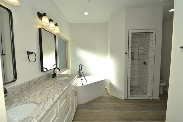 full bathroom featuring hardwood / wood-style floors, vanity, toilet, and independent shower and bath