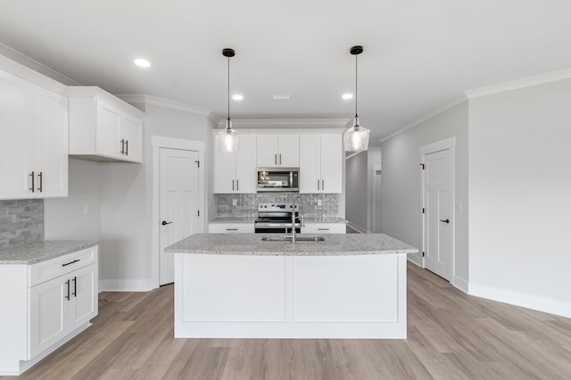 kitchen featuring stainless steel appliances, white cabinetry, a center island with sink, and light hardwood / wood-style flooring