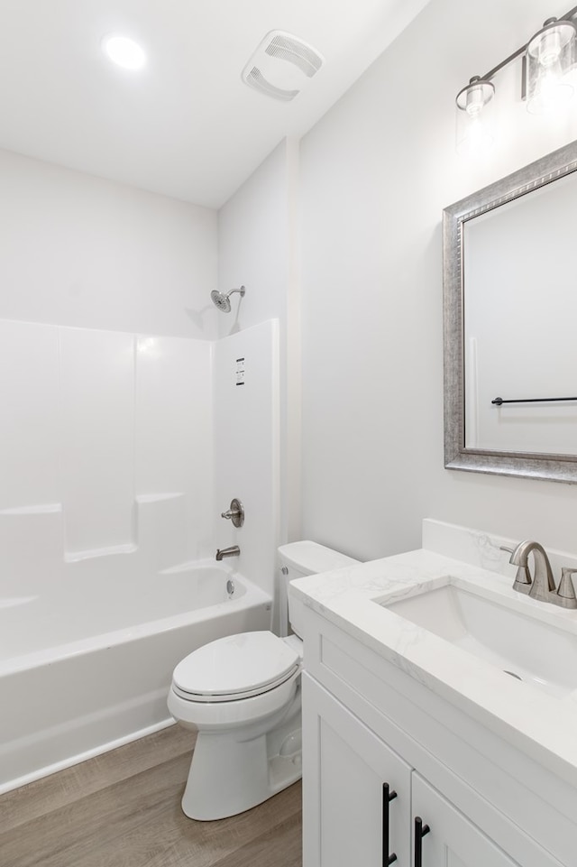 full bathroom with vanity, toilet, wood-type flooring, and tub / shower combination