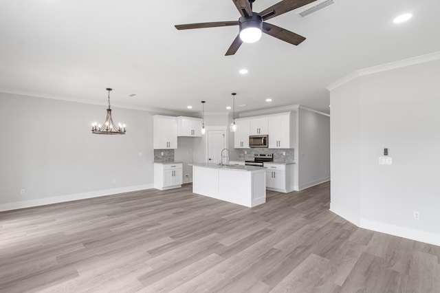 kitchen with sink, stainless steel appliances, decorative light fixtures, a kitchen island with sink, and white cabinets