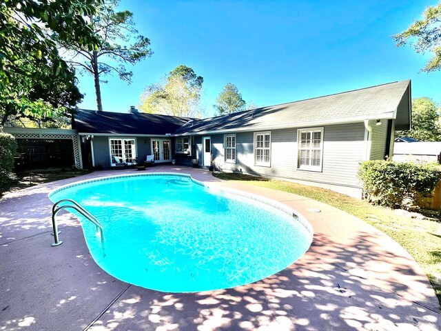 view of swimming pool featuring french doors