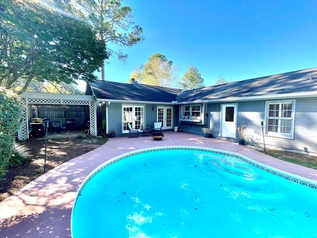 view of swimming pool featuring a patio area and french doors