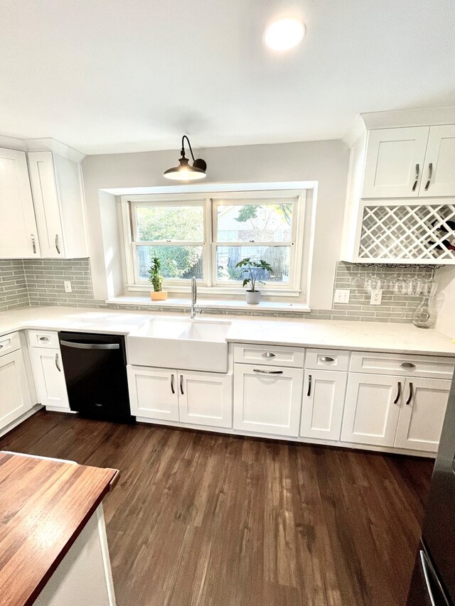 kitchen featuring dishwasher, decorative backsplash, and white cabinetry