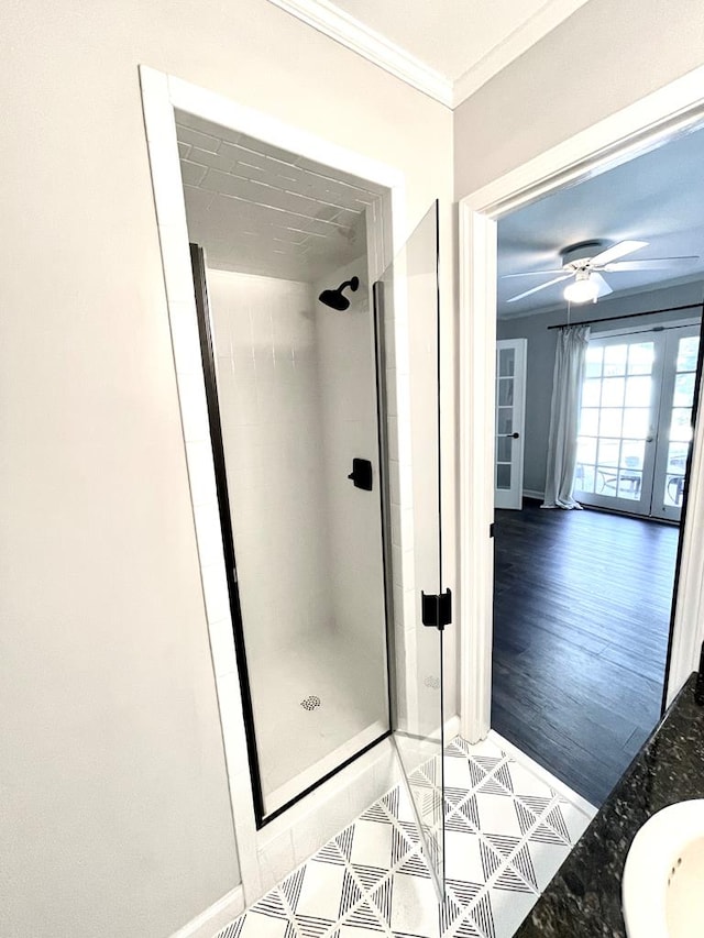 bathroom featuring hardwood / wood-style floors, ceiling fan, a tile shower, and ornamental molding