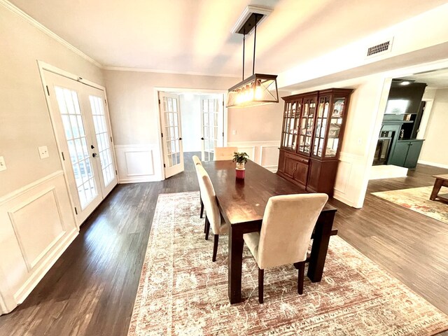 dining area with crown molding, french doors, and dark wood-type flooring