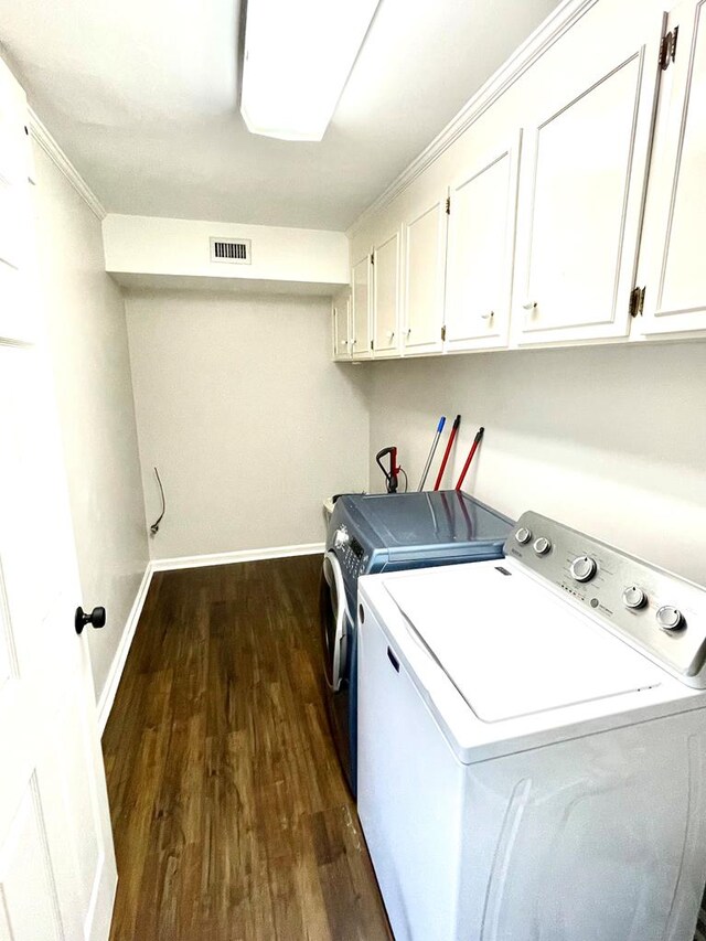 washroom featuring cabinets, separate washer and dryer, dark hardwood / wood-style floors, and ornamental molding